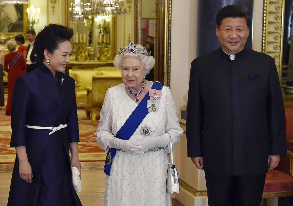China's President Xi Jinping, right, and his wife Peng Liyuan,left, accompany Britain's Queen Elizabeth and Prince Philip as they arrive for a state banquet at Buckingham Palace in London on Tuesday.