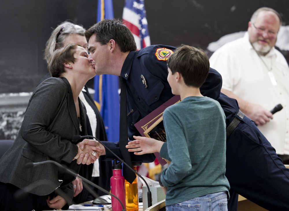 Travis Mead, a captain with Capital City Fire/Rescue, kisses his wife, City Attorney Amy Mead, after receiving the Ken Akerley Fire Service Leadership of the Year award from Mayor Merrill Sanford at the beginning of Tuesday's Assembly meeting. Firefighter/EMT Meg Thordarson was also recognized with the Dell Moffit Award.