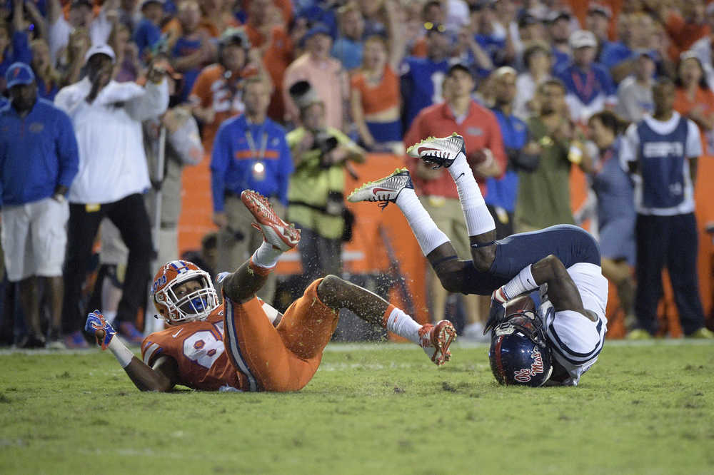 Florida wide receiver Chris Thompson (85), left, tackles Mississippi defensive back Carlos Davis (23) on a punt return during the second half of an NCAA college football game Saturday, Oct. 3, 2015, in Gainesville, Fla. (AP Photo/Phelan M. Ebenhack)