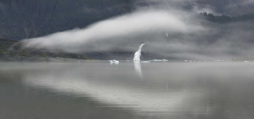 Fog forms over Mendenhall Lake as Nugget Falls flows from recent rainfall on Tuesday.
