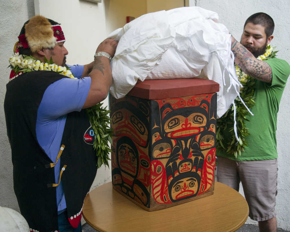 Tlingit Tribe members from Klawock, Alaska Jonathan Rowan, left, and Lawrence Armour unveil a carved Alaskan storage box at the Honolulu Museum of Arts, Thursday, Oct. 22, 2015, in Honolulu.   A totem pole, stolen by actor John Barrymore during a sailing trip to Alaska in 1931, was returned to the Tlingit Tribe by the Honolulu Museum of Arts today, where it was on display since the early 1980s.  The totem pole was carved by the ancestors of the Tlingit Tribe.  The box was a thank you gift for the return of their totem pole.  (AP Photo/Marco Garcia)