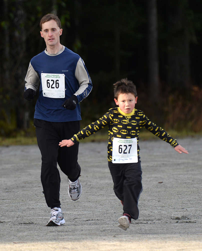 Shawn Miller, age 35, follows Michael Miller, age 6, towards the finish of Juneau's 1st Annual PolioPlus Fun Run on Saturday at the Riverbend Elementary School covered playground. A slideshow of photos is online at Juneauempire.com.