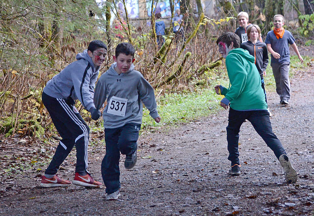 A runner escapes zombies during Sunday's 4th Annual Zombie Run 5K or 1-mile run on the Treadwell Trails at Sandy Beach. The event was a fundraiser for the Harborview Elementary Triathlon Club.