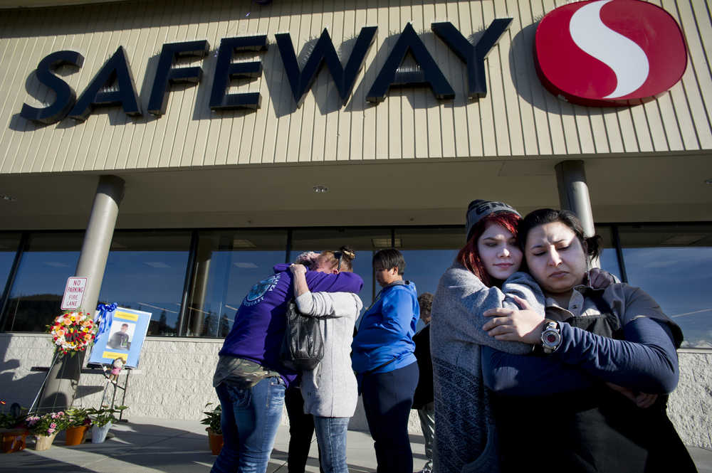 Safeway employees Heather Abrams and Aileen Sanchez, right, embrace during a memorial Monday for former employee Brandon Cook, 30, who was murdered last week. Police have charge Christopher Strawn with the crime and he is being held on $1 million bail.