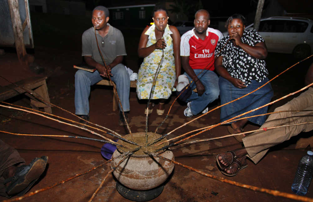In this photo taken Oct. 18, Ugandans drink a local brew known as "malwa" at the Charismatic Club in the Kitintale district of Kampala, Uganda.