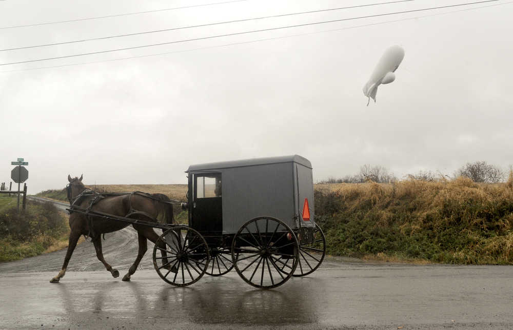 An unmanned Army surveillance blimp which broke loose from its ground tether in Maryland floats through the air about 1,000 feet about the ground while dragging a several thousand foot tether line just south of Millville, Pa., Wednesday, Oct. 28, 2015. (Jimmy May/Bloomsburg Press Enterprise via AP) MANDATORY CREDIT
