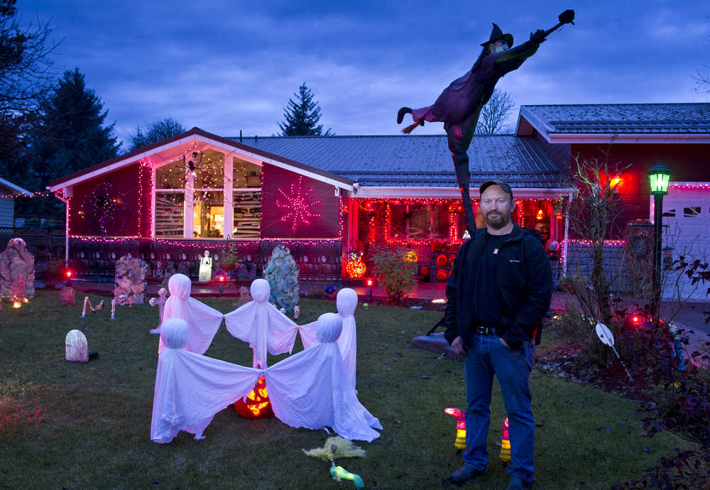 Dan Earls poses for a picture in his front yard decorated for Halloween. "I like Halloween and the neighborhood sure likes it," says Earls. Earls is also turning his garage into a seven-room haunted house for trick-or-treaters to venture through Saturday night. "I work as a mechanic so this is my fun thing."