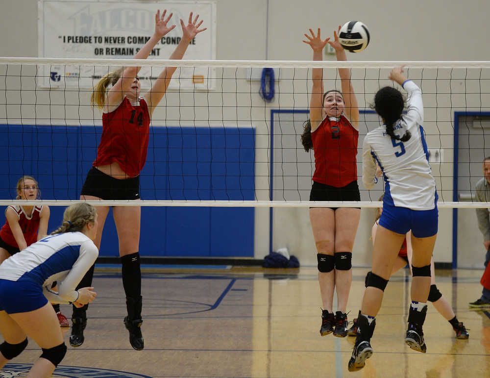 Thunder Mountain sophomore Maxie Saceda Hurt (5) hits a shot against Juneau-Douglas seniors Maddie McKeown (14) and Martina Worden (2) during volleyball action on Friday at TMHS.