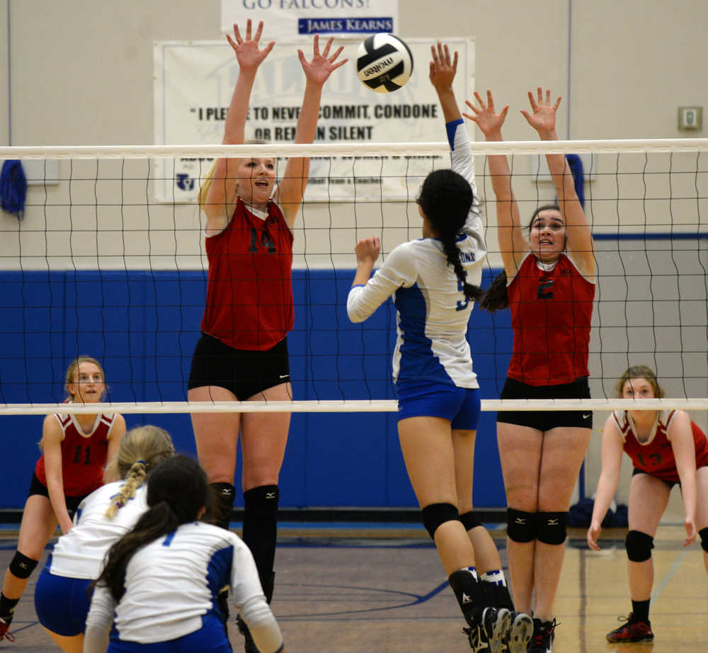 JDHS seniors Maddie McKeown (14) and Martina Worden (2) try to block a tip by TMHS sophomore Maxie Saceda-Hurt during weekend volleyball action. A slideshow of photos is online at juneauempire.com.