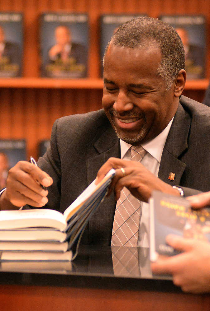 Presidential candidate Ben Carson, autographs his book during his book signing event in Lake Sumter Landing, The Villages, Fla., Monday, Nov. 2, 2015. (George Horsford/Daily Sun via AP)