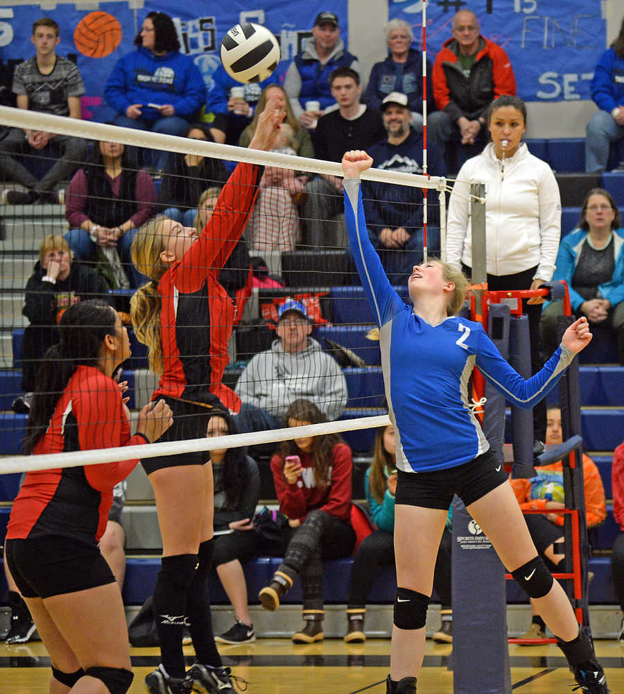 Thunder Mountain's Mary Landes (2) tips a shot over Juneau-Douglas' Kallen Hoover and Soana Kelepi during the 4A Region V tournament's elimination match play on Saturday at TMHS.