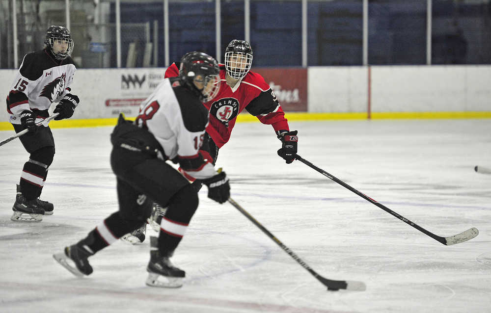 Juneau-Douglas High School junior forward Quin Gist moves in to defend the Yukon Huskies' Kyron Crosby (18) during hockey action at Whitehorse on Saturday.