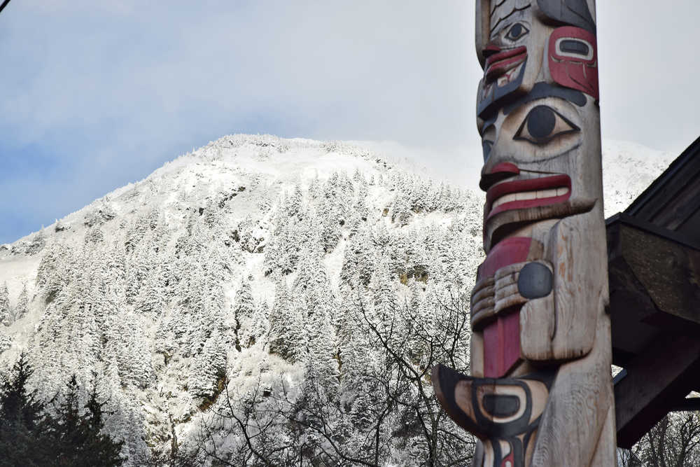 One of two totem poles in front of the Gajaa Hit building in the Willoughby District is seen in front of a snow-covered Mount Juneau on Wednesday, Nov. 11, 2015. A trace of snow was recorded overnight at Juneau International Airport, 0.4 inches in the Mendenhall Valley and 3.6 inches at the base of Eaglecrest Ski Area, but no snow was recorded in downtown Juneau. Alaska's capital city has yet to record measurable snow at the airport, its official measuring site.