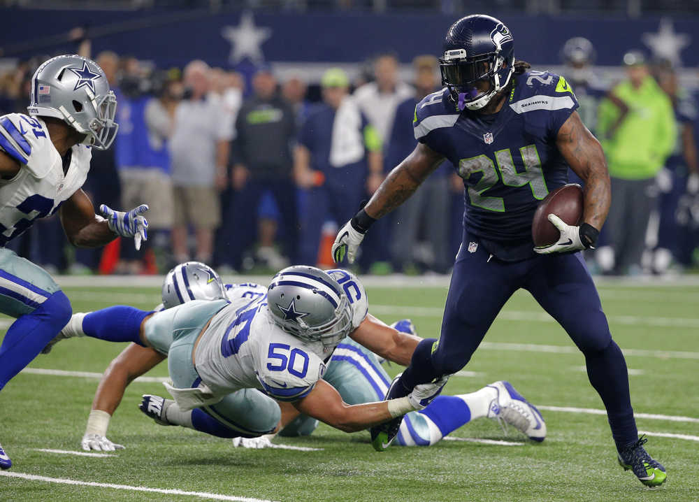 Seattle Seahawks running back Marshawn Lynch (24) breaks through a tackle-attempt by Dallas Cowboys' Sean Lee (50) as Cowboys Byron Jones, left, comes over to help on the running play in the second half of an NFL football game Sunday, Nov. 1, 2015, in Arlington, Texas. (AP Photo/Brandon Wade)