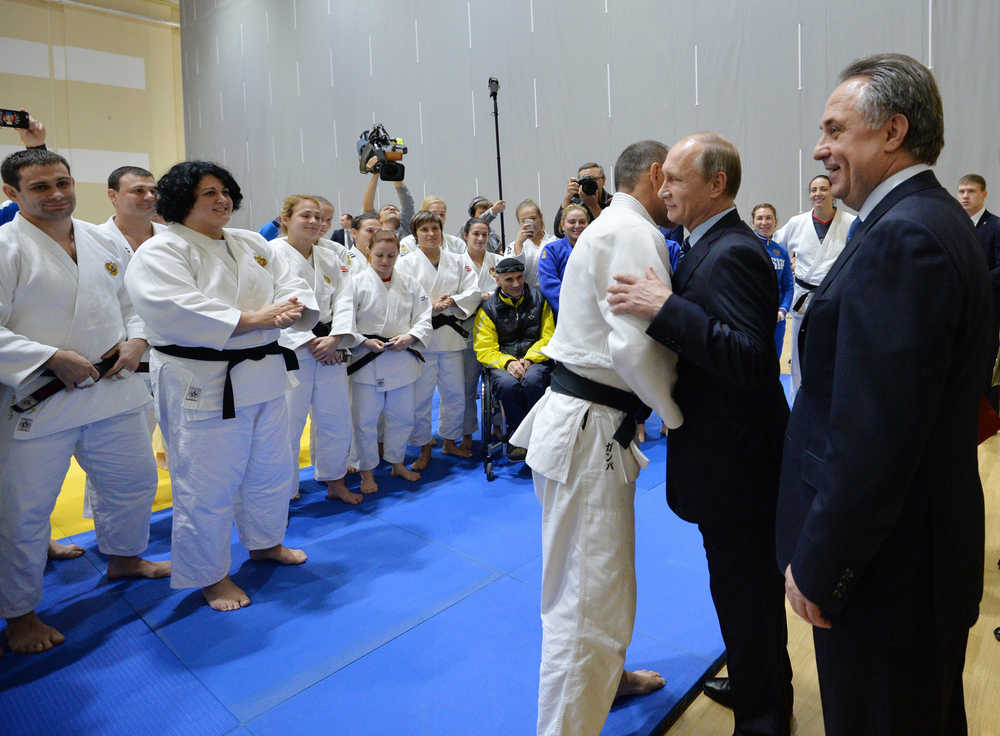 Russian President Vladimir Putin, second right, embraces with an athlete as Sports Minister Vitaly Mutko, right, smiles during a visit to the federal government center "South Sports" before their late-night meeting with the heads of Russia's sports federations in the Black Sea resort of Sochi, Russia, on Wednesday. (Alexei Druzhinin | RIA-Novosti, Kremlin Pool Photo via AP)