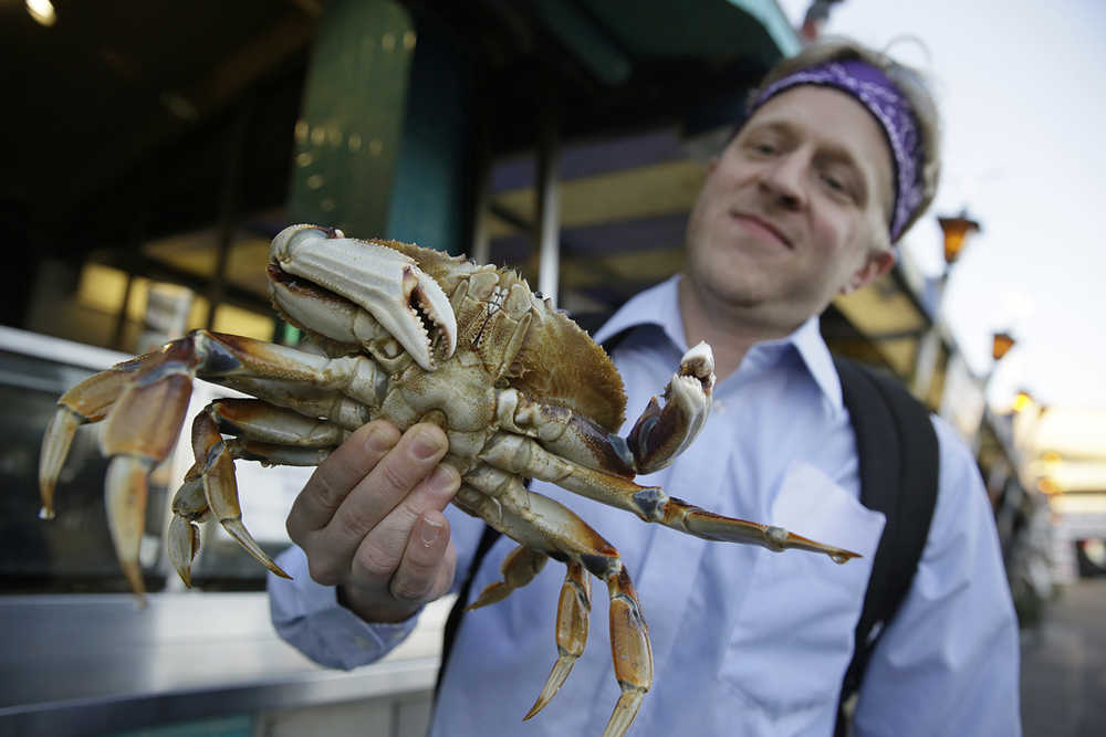 In this photo taken Nov. 10, Michael Bair, of Lexington, Kentucky, holds an imported Dungeness crab from the Northwest at Fisherman's Wharf in San Francisco.