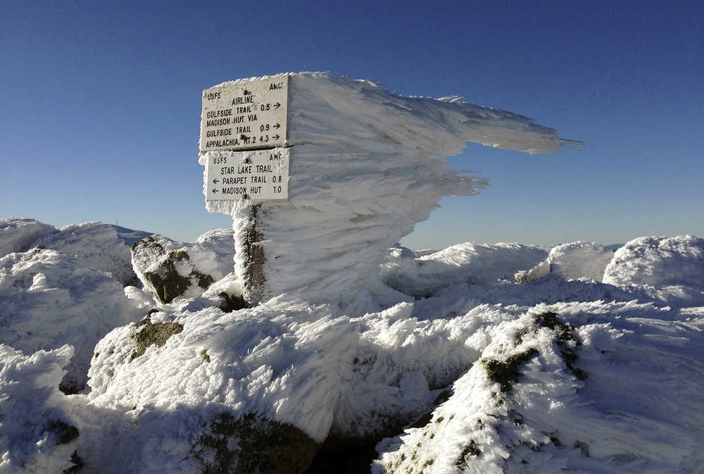 Rime ice extends several feet horizontally from a sign marking the summit of 5,774-foot Mount Adams, the second highest mountain in New England, on Tuesday, Nov. 17, 2015, in northern New Hampshire. Monday's freezing fog and strong winds formed the rime ice, creating a winter wonderland above treeline in New Hampshire's aptly named White Mountains. (AP Photo/Robert F. Bukaty)