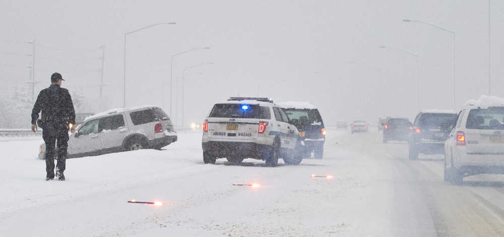 A Juneau Police Department officer responds to a vehicle in the meridian on Egan Drive Wednesday morning.
