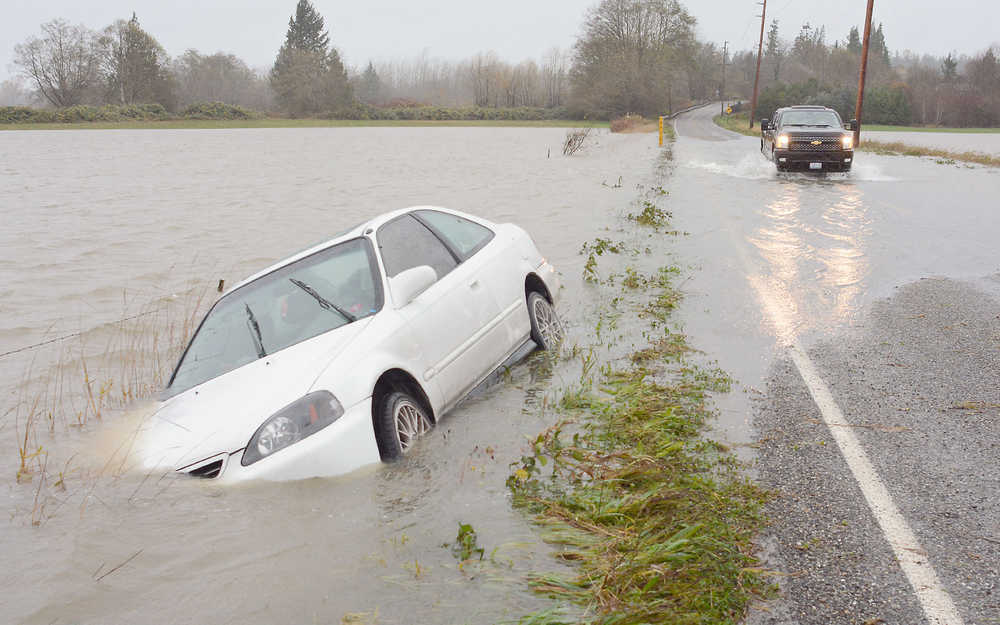 A Honda Civic sits in the ditch off Swan Road after SVC student Chris Dankert hit some high water on his way to Clear Lake from Mount Vernon, Wash. on Tuesday. Dankert was not injured in the incident. The Skagit River will rise about two feet above flood stage late Wednesday in Mount Vernon according to the Northwest River Forecast Center.