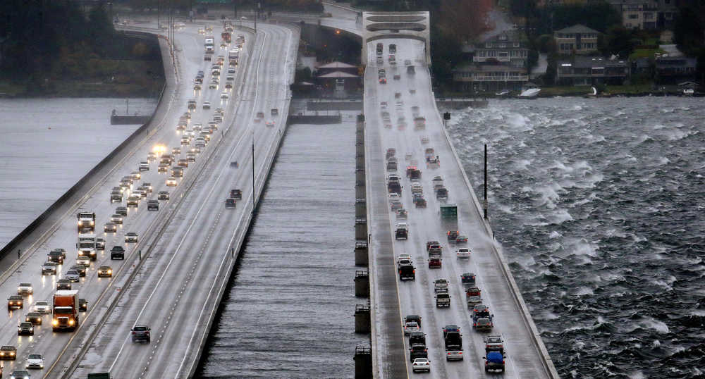 Eastbound traffic lanes, right, on Interstate 90 are dampened by wind-driven waves from the south as the floating bridge calms Lake Washington to the north, left, on Tuesday in Seattle. Rain and high winds snarled the morning commute in the Puget Sound area and the Inland Northwest braced for severe weather that could include wind gusts to 70 mph. The National Weather Service says a Pacific storm system, which arrived Tuesday may include sustained winds of 45 mph that could topple trees and cause power outages.