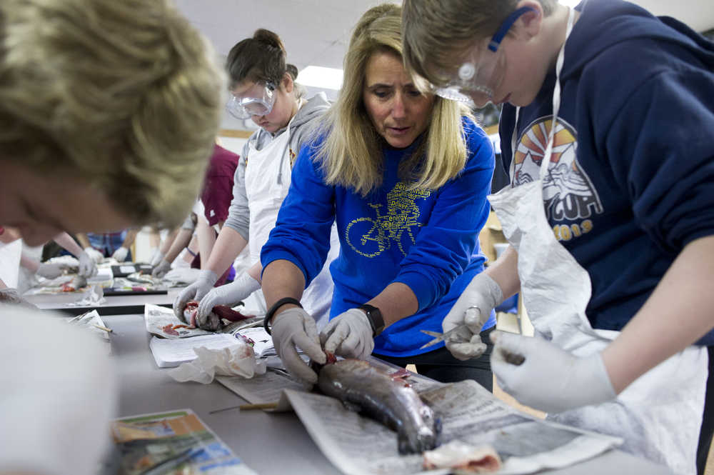 Teacher Rebecca Farrell helps Gabe Miller dissect a jack king salmon at Floyd Dryden Middle School on Friday.