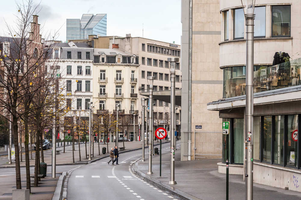 Two people cross a deserted street near the main train station in the center of Brussels on Sunday. Residents of the Belgian capital awoke to largely empty streets as the city entered its second day under the highest threat level and the city kept subways and underground trams closed.