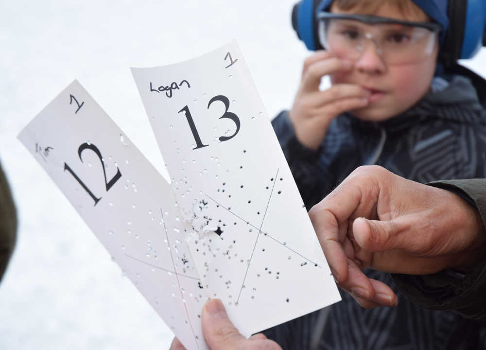 Logan Miller, 12, bites his fingernails as he awaits the result of his attempt in the card shoot event on Saturday, Nov. 21, 2015. This event, part of the 2015 Turkey Shoot, invites participants to fire shotguns at stationary targets. The person whose shot is closest to the center of an X marked on the card wins a frozen turkey.