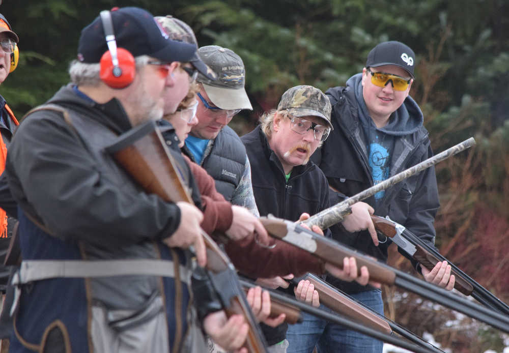 Wayne Wilson looks down the firing line at the next shooters after advancing to the next round in the Annie Oakley competition Saturday, Nov. 21, 2015 at the Juneau Gun Club's Turkey Shoot. Eric Verrelli, at back, won the initial competition, taking home a frozen turkey.