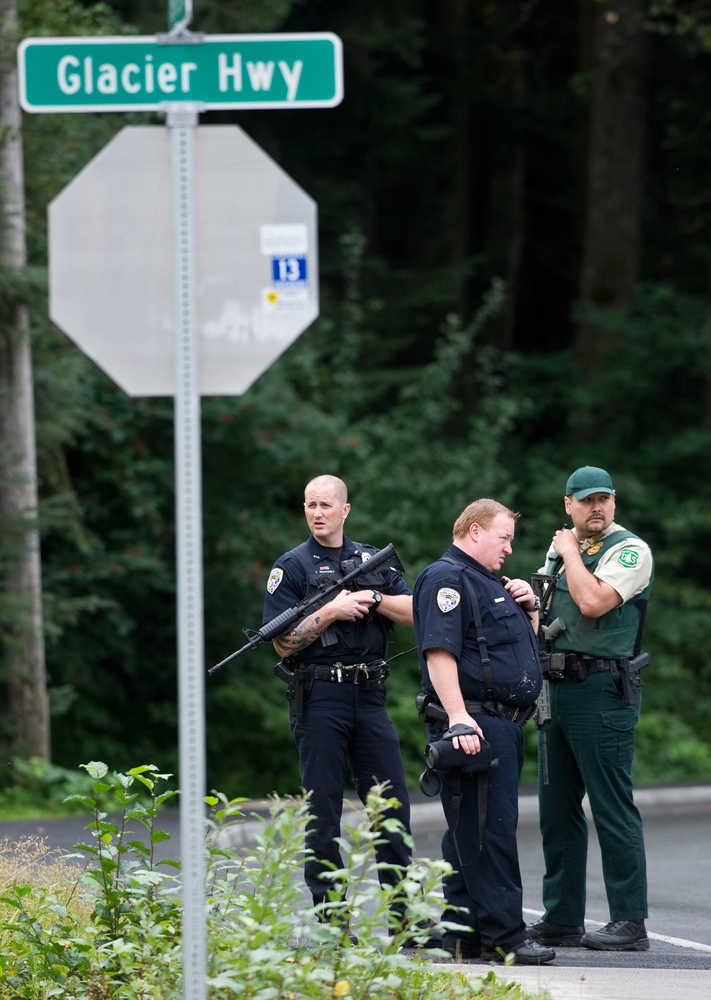 Juneau police officers joined by a U.S. Forest Service enforcement officer wait at the corner of Glacier Highway and Berners Avenue during a search for a man who robbed the Heritage Coffee Company stand at the Airport Shopping Center in August 2013.