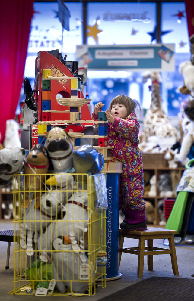 Esme Woolford, 2, explores the toys at The Imagination Station during a stop at the downtown shop with her mother, Noelle, on Monday.