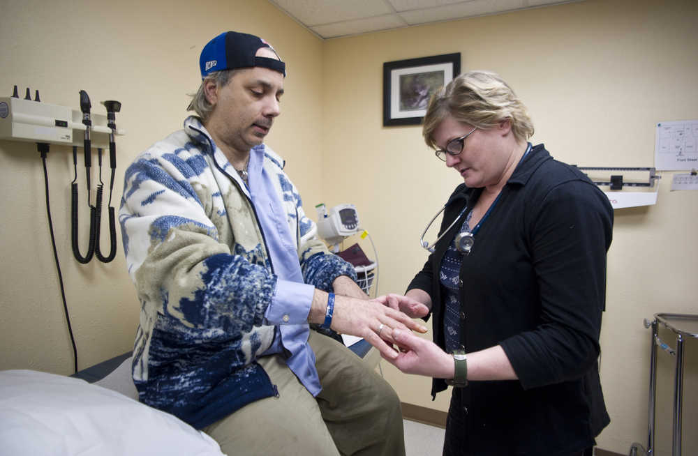 Nurse Practitioner Cynthia Mattoni, the new medical provider at Front Street Community Health Center, helps Michael John Townsend with a hand injury at the clinic on Wednesday.