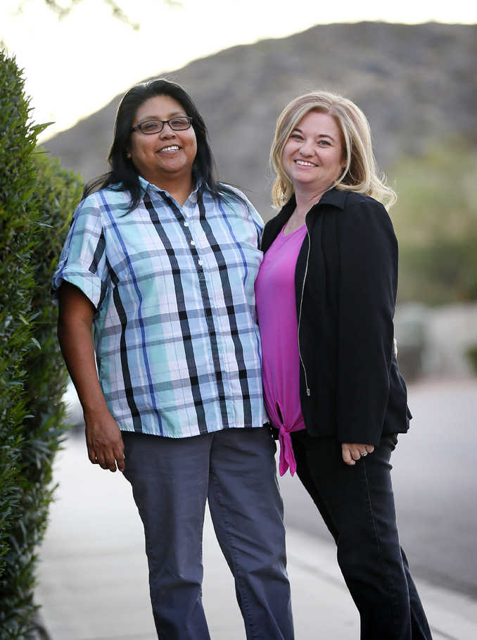 In this Nov. 9 photo, Cleo Pablo, left, and her wife, Tara Roy-Pablo, stand outside their home in Phoenix.