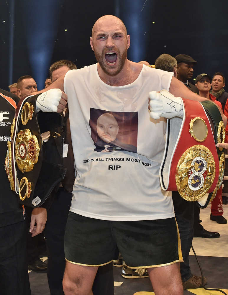Britain's new world champion Tyson Fury celebrates with the WBA, IBF, WBO and  IBO belts after winning the world heavyweight title fight against Wladimir Klitschko in the Esprit Arena in Duesseldorf, western Germany, Sunday, Nov. 29, 2015. (AP Photo/Martin Meissner)