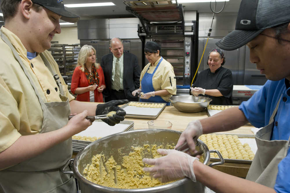 Gov. Bill Walker and his wife, Donna, watch as Kyle Avis, left, Sherrilyn Stein, Cheryl Griffiths and Ken Carrillo, right, make lemon crinkle cookies at the Breeze In kitchen in Lemon Creek on Wednesday. The bakery is making 22,000 cookies in 11 flavors plus fresh donut holes for the Governor's Open House to be held on Tuesday, Dec. 8 from 3 to 6 p.m.