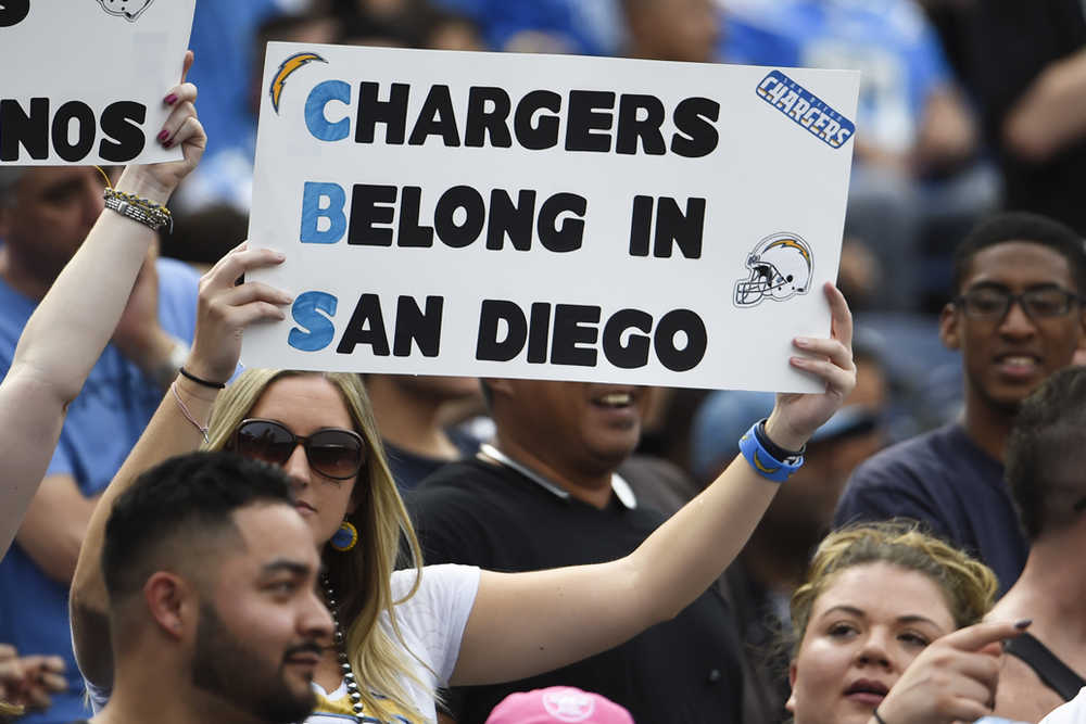 In this Oct. 25 photo, a San Diego Chargers fan holds a sign against the team's potential relocation to Los Angeles during a game against the Oakland Raiders in San Diego.