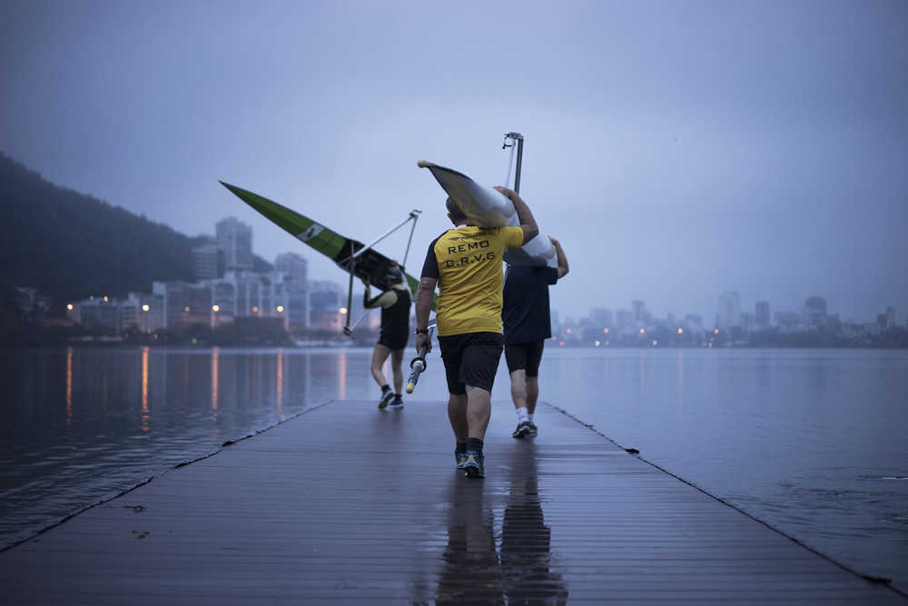 In this Nov. 4 photo, rowers carry boats at the Rodrigo de Freitas Lagoon in Rio de Janeiro, Brazil. Athletes in Rio test events have tried many tricks and treatments to avoid falling ill from its contaminated waters, including bleaching rowing oars, hosing off their bodies the second they finish competing, and preemptively taking antibiotics, which have no effect on viruses.