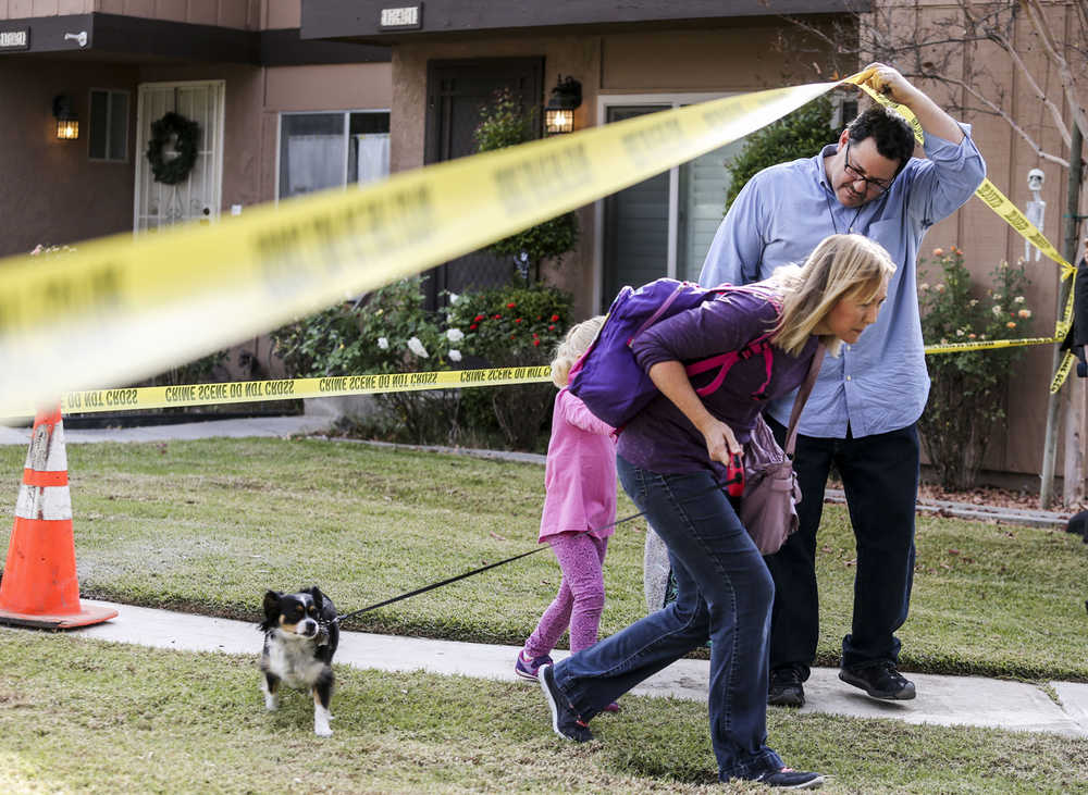 People leave their home in the neighborhood near a home being investigated in connection to the shootings in San Bernardino, Thursday, Dec. 3, 2015, in Redlands, Calif. A heavily armed man and woman opened fire Wednesday on a holiday banquet for his co-workers, killing multiple people and seriously wounding others in a precision assault, authorities said. Hours later, they died in a shootout with police. (AP Photo/Ringo H.W. Chiu)