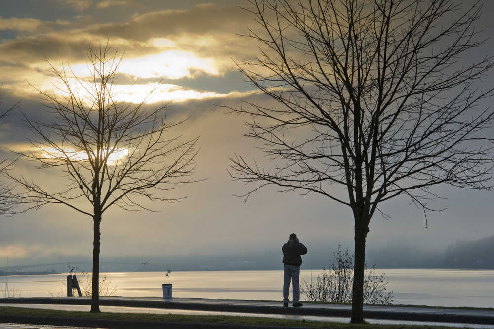 Mike Reed photographs the sunrise from the Wayside Park on Channel Drive on Thursday. The National Weather Service forecast for Friday calls for sunny with patchy fog in the morning. Highs around 35.