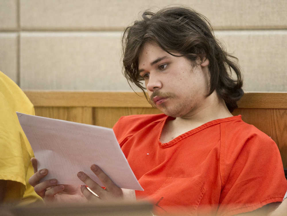 Kevin Scott Nauska, 19, reads his charging documents in Juneau District Court on Friday before his arraignment on charges of second-degree murder and assault charges in the stabbing death of Jordon J. Sharclane, 37, and stabbing injuries to Sharclane's son, Michael, 19.