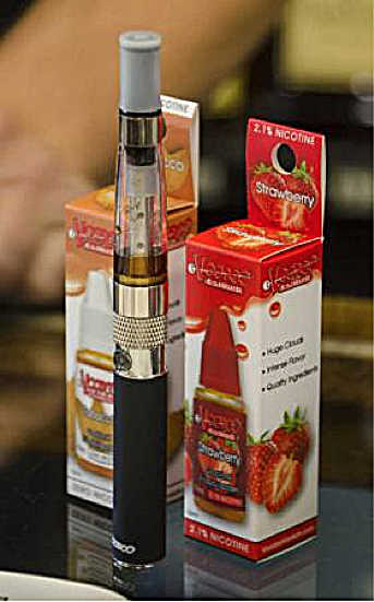 In this Nov. 7, 2014, photo, a vape-pen containing a nicotine-free, coffee-flavored liquid sits in Percy's Liquor as a sample.