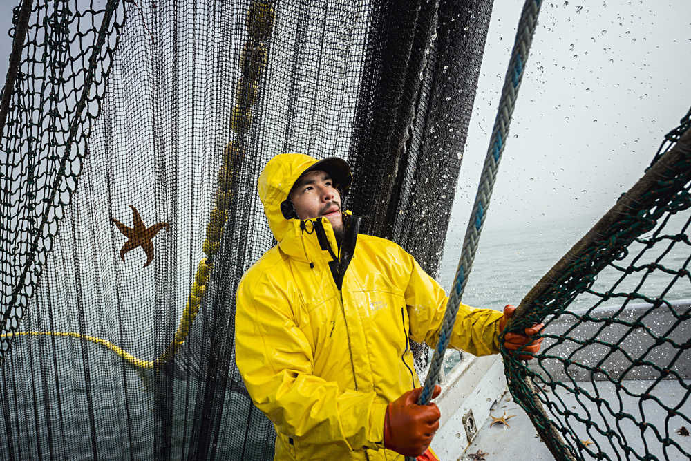 Loyd Ashouwak stacks the net and lead-line of a herring seine while fishing in the Togiak herring fishery.