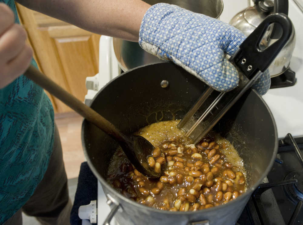 Raw Spanish peanuts get mixed into a boiling sugar and butter mixture as Assembly member Debbie White makes peanut brittle in her home kitchen on Monday.