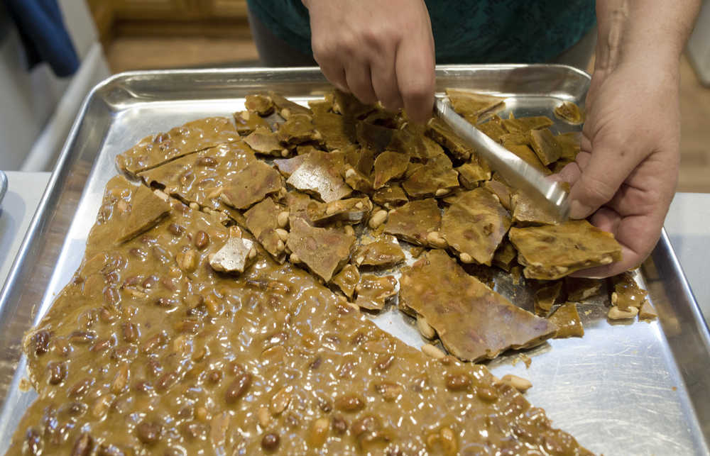 Assembly member Debbie White breaks up peanut brittle she made in her home kitchen on Monday.