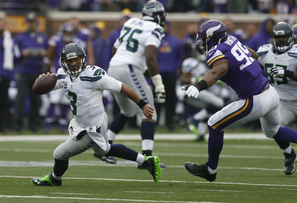 Seattle Seahawks quarterback Russell Wilson escapes the pressure of Minnesota Vikings defensive end Danielle Hunter on Sunday.