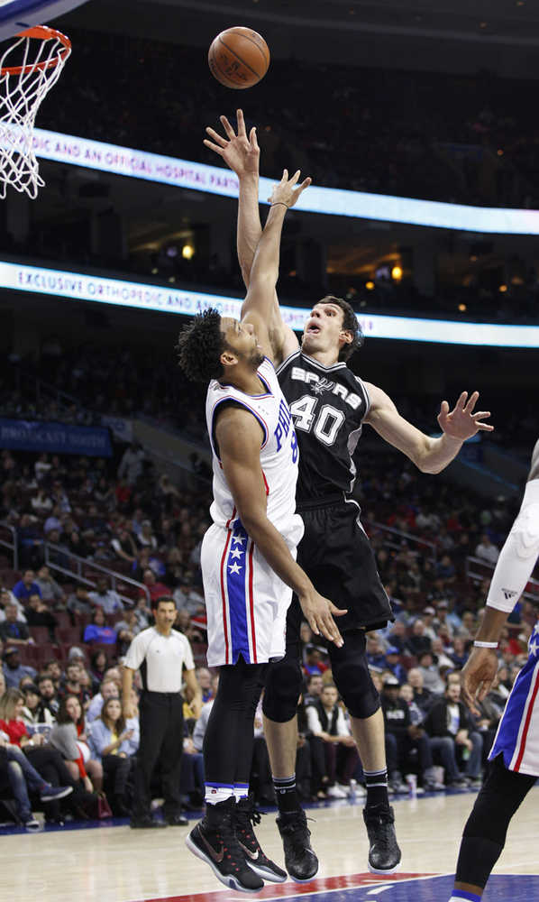 San Antonio Spurs' Boban Marjanovic, right, puts up the shot over Philadelphia 76ers' Jahlil Okafor, left, Monday.