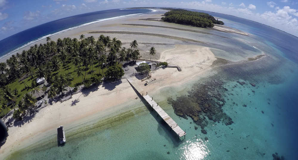 FILE - In this Nov. 8, 2015 aerial file photo , a small section of the atoll that has slipped beneath the water line only showing a small pile of rocks at low tide on Majuro Atoll in the Marshall Islands. They barely break the surface of the ocean but in the U.N. talks on how to stop rising seas and other hazards of a warming planet, small island nations have the moral high ground. While most countries think of climate change in terms of economic costs, Pacific atolls and remote island groups in the Indian Ocean and Caribbean picture a world map without them on it. Rising seas are already eroding their coast lines and contaminating their freshwater wells. Many are in the path of typhoons and hurricanes that scientists say could become more powerful as the climate warms.  (AP Photo/Rob Griffith, File)