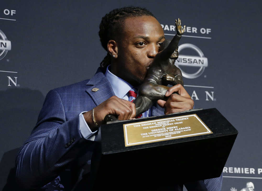Alabama's Derrick Henry kisses the Heisman Trophy Saturday in New York.