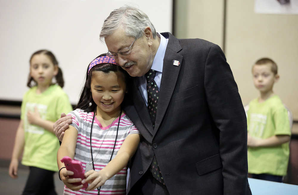 In this Dec. 7 photo, Iowa Gov. Terry Branstad poses for a photo with sixth-grader Elaine Wang before speaking at a proclamation signing at Jordan Creek Elementary School, in West Des Moines, Iowa.