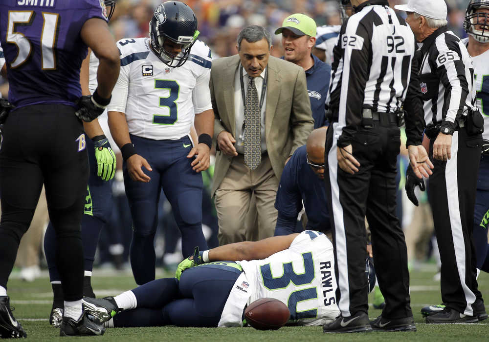 Seattle Seahawks quarterback Russell Wilson looks at an injured Seahawks running back Thomas Rawls Sunday.