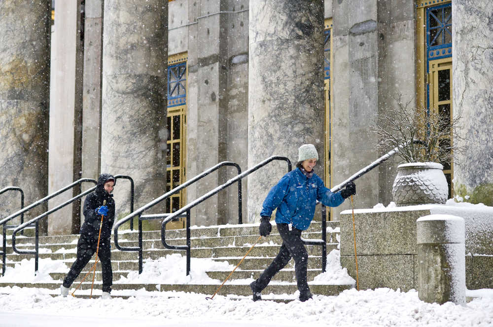Jan Rutherdale and her daughter, Isabel Bush, ski past the Capitol during Monday's snow showers. The National Weather Service forecast for Tuesday calls for numerous rain and snow showers. Snow accumulation to 1 inch. Highs 32 to 36. West wind 10 to 15 mph.